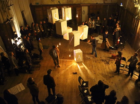 Photograph of an event at the Camden People's Theatre for The Coney Theatre Group, with large boxes hung up filled with light and letters on them.