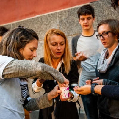 Photograph of a group of people picking something from a cup.