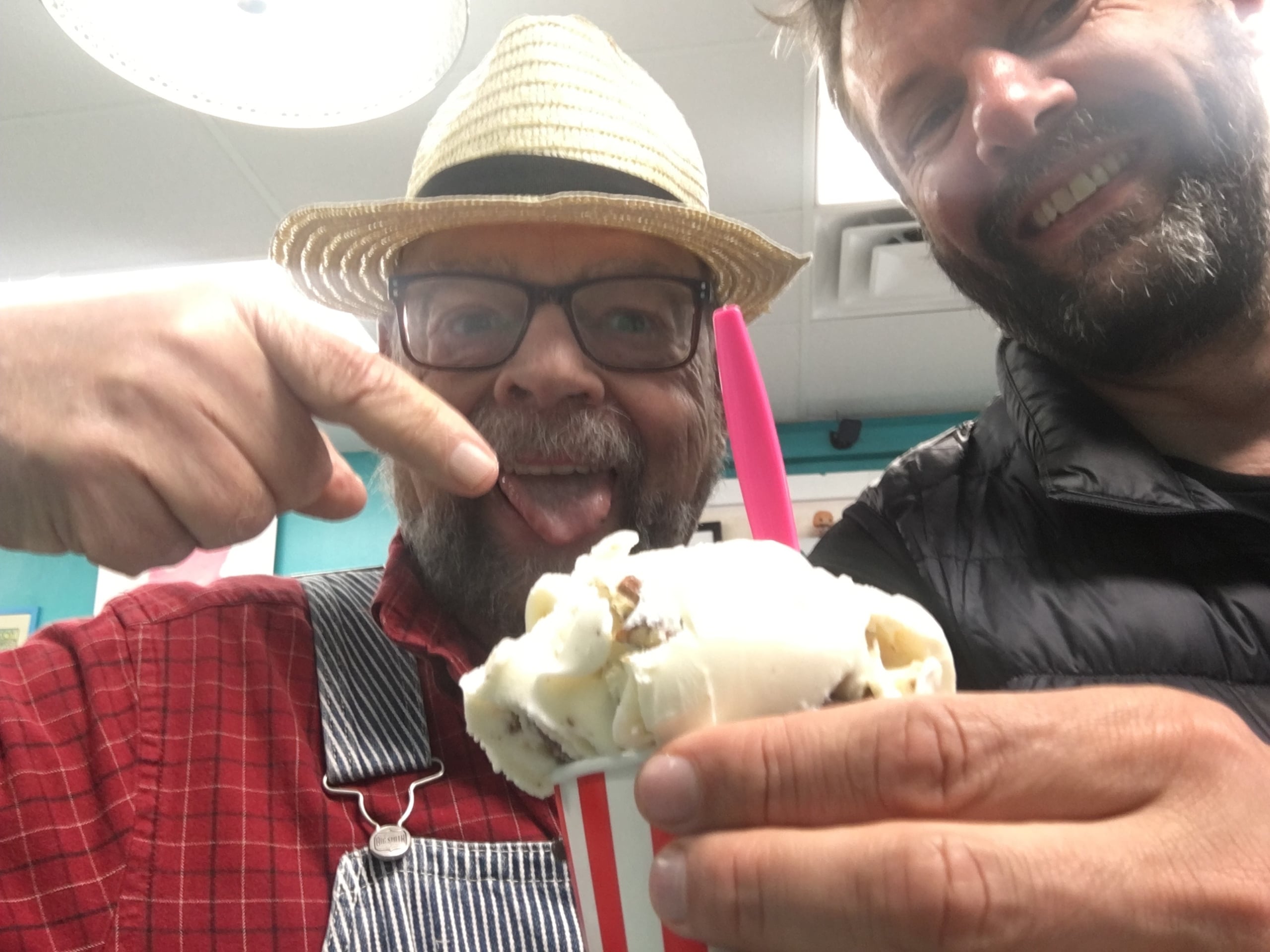 Photograph of two men, one is holding an ice cream the other is pointing at it.