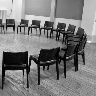 Photograph of empty chairs arranged in a circle.